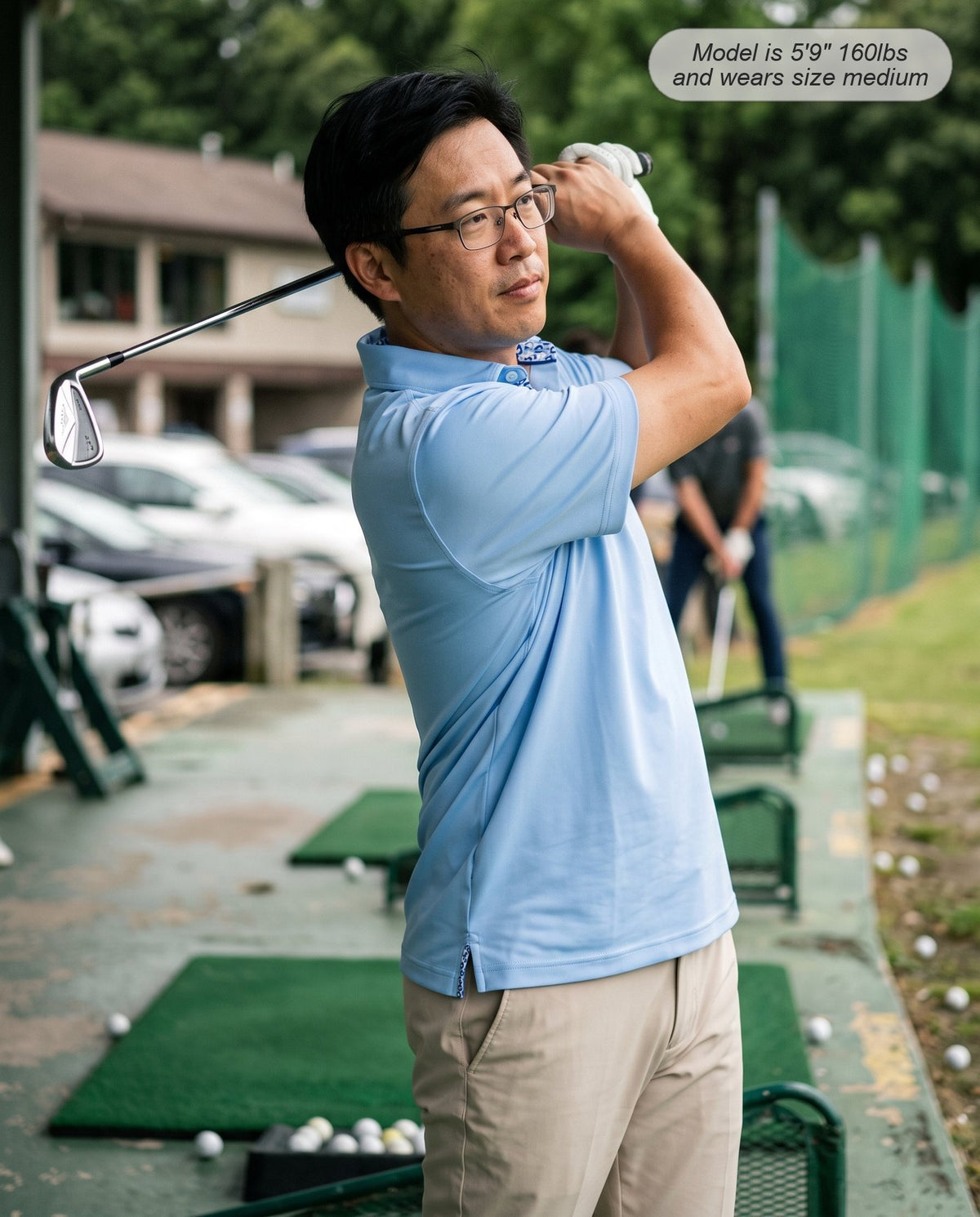 Man wearing the Meridian golf polo in powder blue mid-swing at the driving range