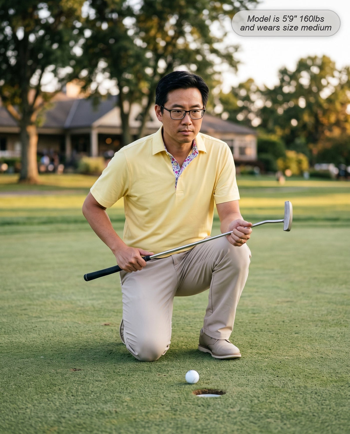 Man wearing the Meridian golf polo in butter yellow reading a putt on the practice green