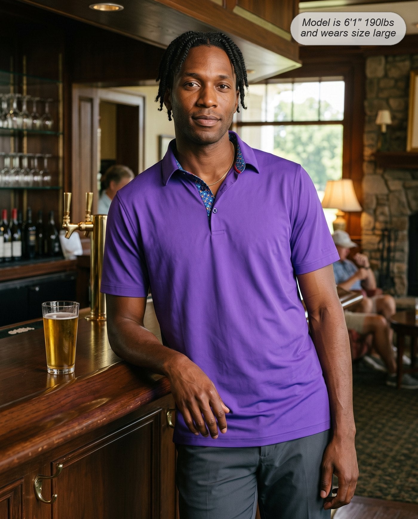 Man wearing the Meridian golf polo in violet at the clubhouse bar