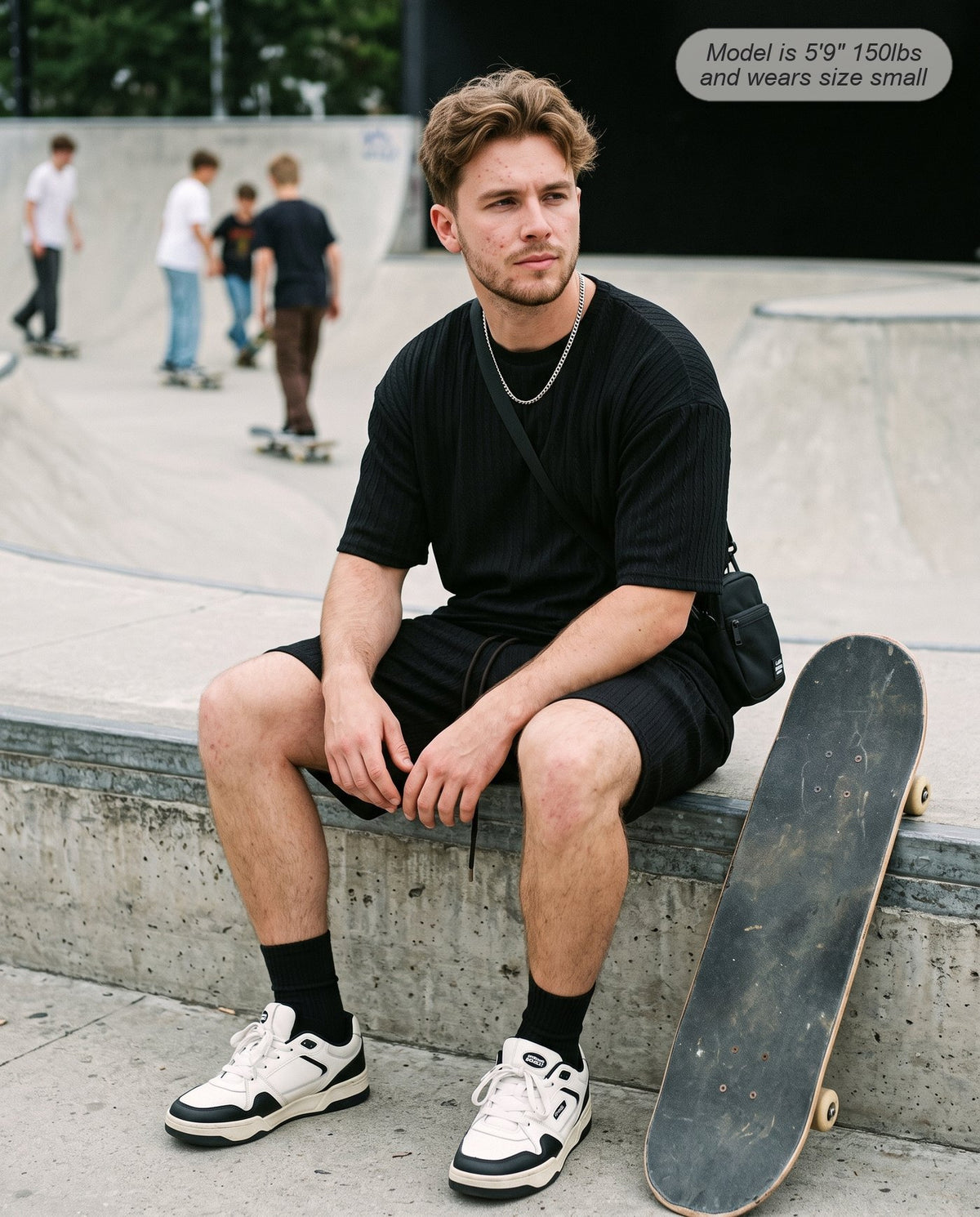 Man wearing the Monarch lounge short set in black at a skate park