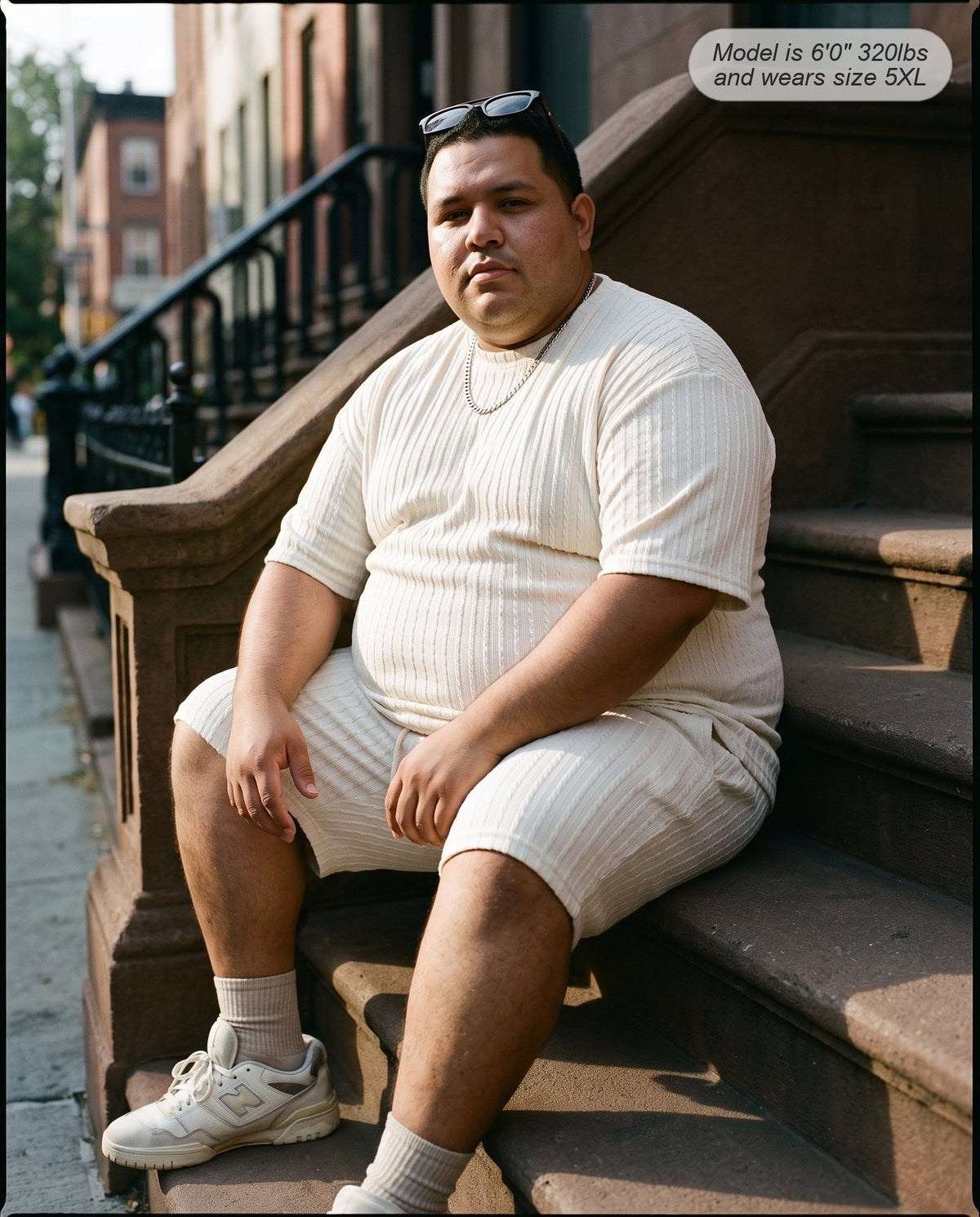 Man wearing the Monarch lounge short set in white on a brownstone stoop
