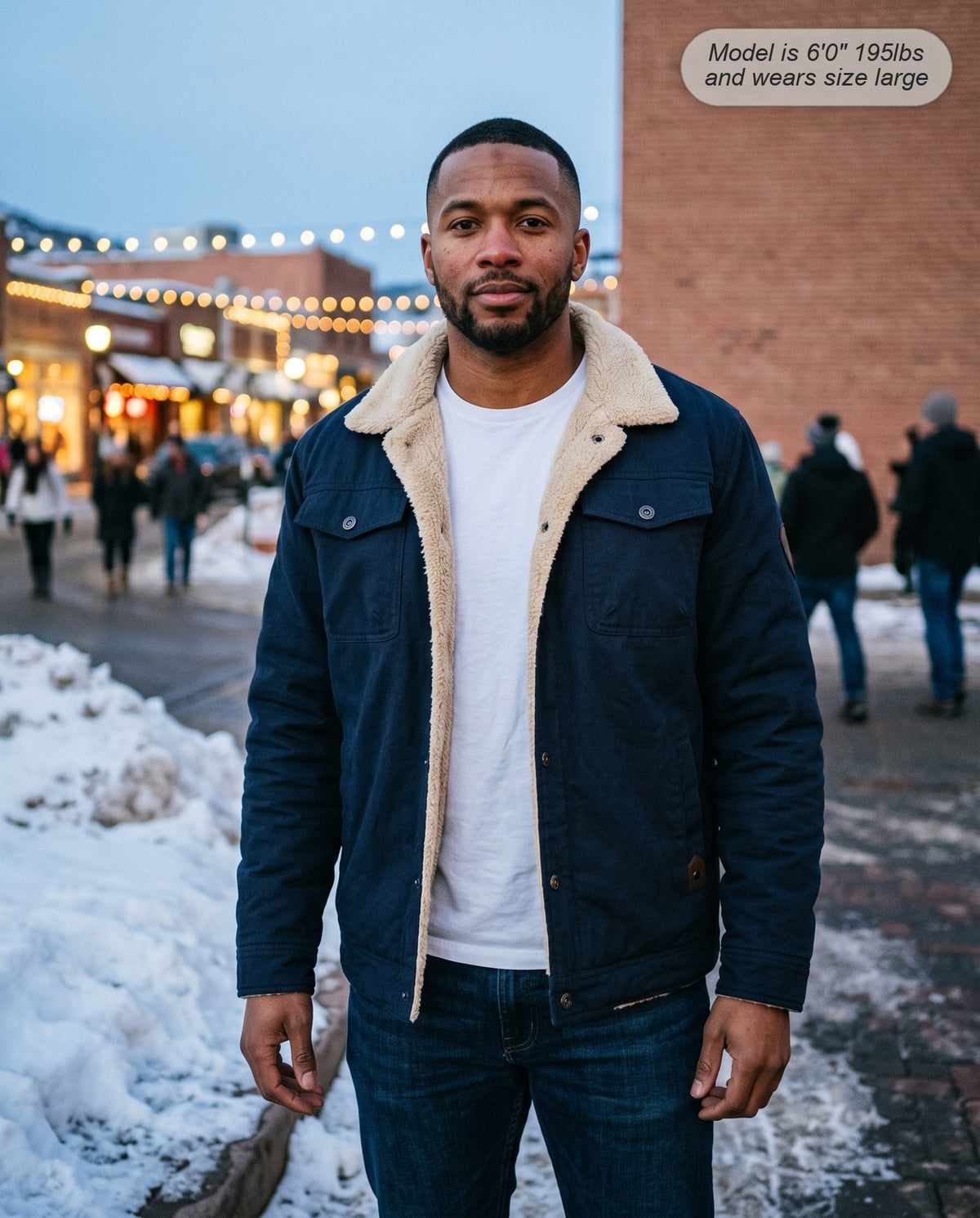 Man wearing the Sentinel sherpa jacket in navy on a ski-town street
