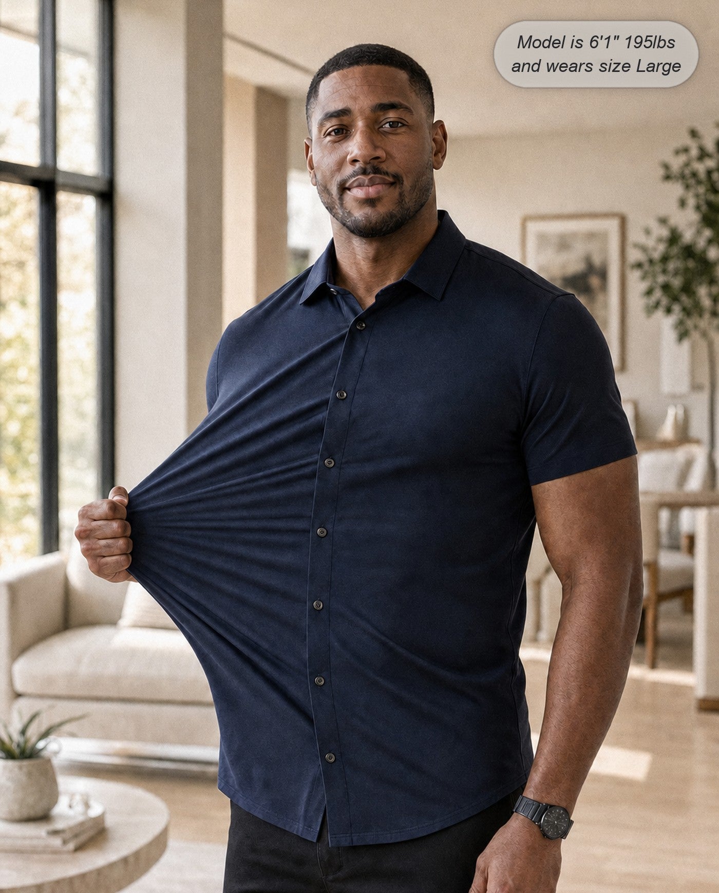 Sovereign stretch dress shirt in navy, short sleeve, stretching the fabric in a modern lounge