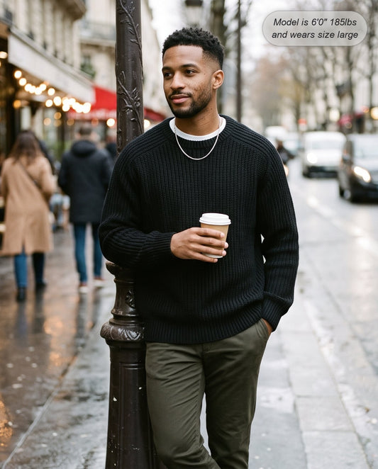 Man wearing the Admiral relaxed ribbed knit sweater in black on a city street