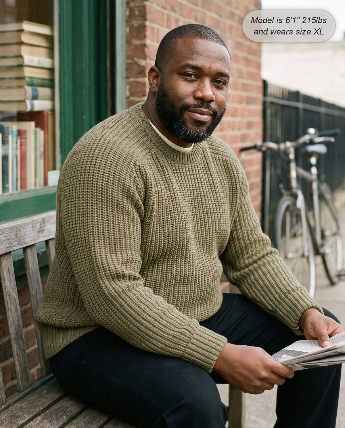Man wearing the Admiral relaxed ribbed knit sweater in olive outside a bookshop