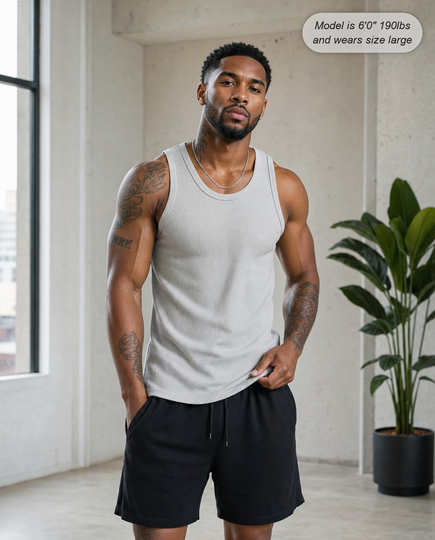 Man wearing the Apex ribbed tank in silver in a loft