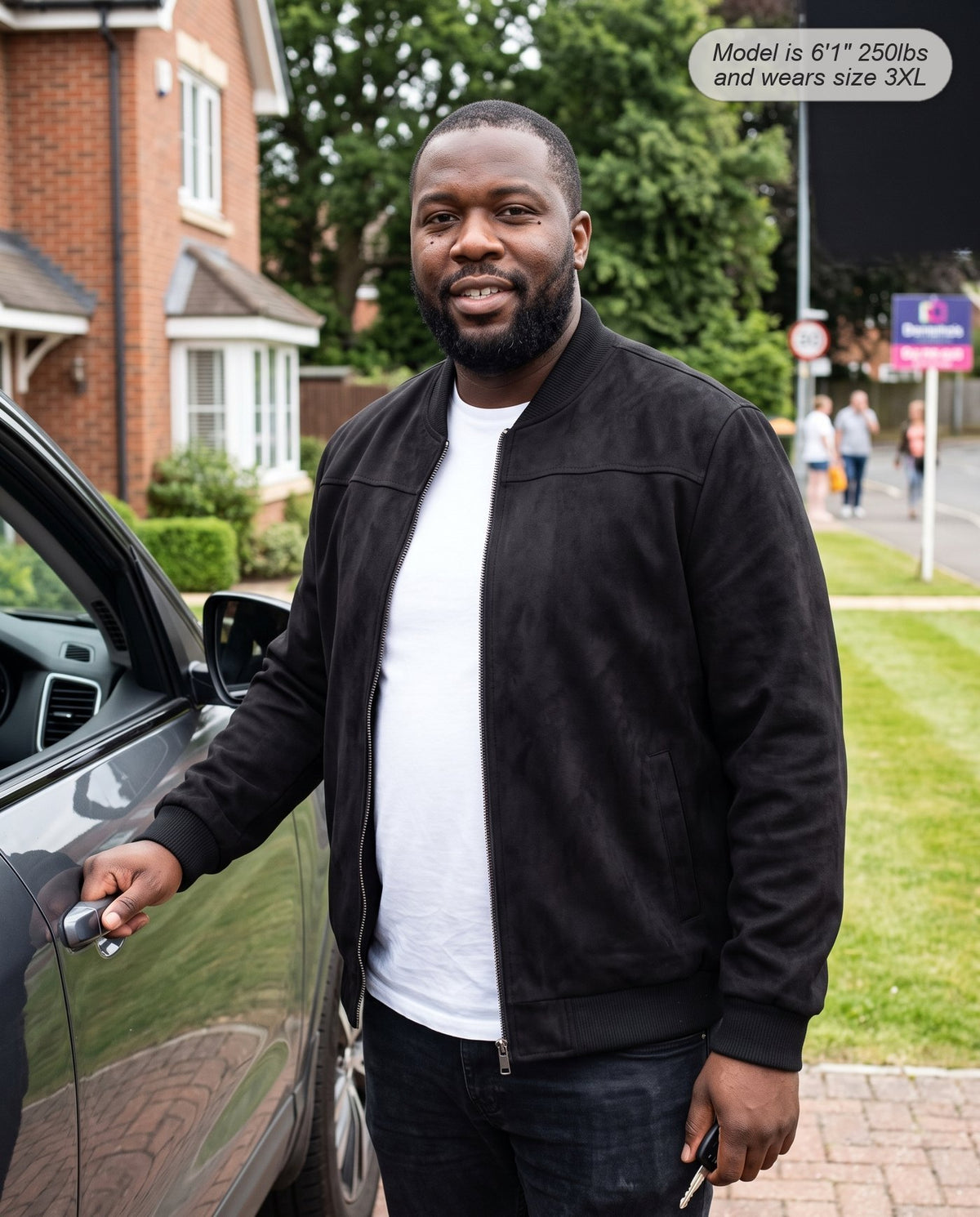 Man wearing the Atlas suede bomber jacket in black on a home driveway