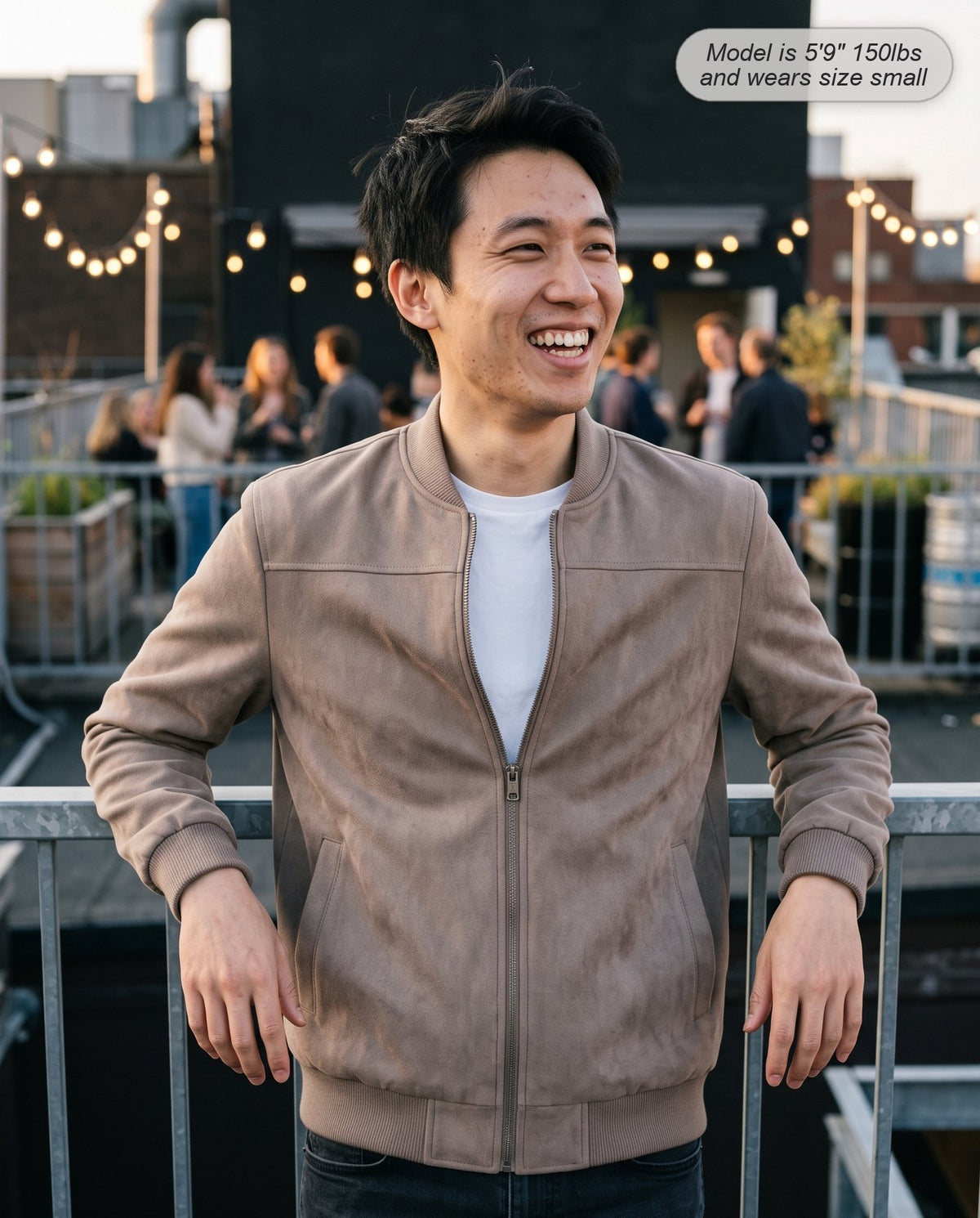 Man wearing the Atlas suede bomber jacket in taupe on a rooftop terrace