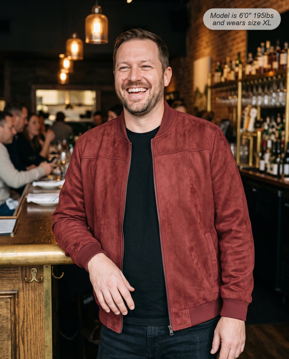 Man wearing the Atlas suede bomber jacket in brick red at a restaurant bar