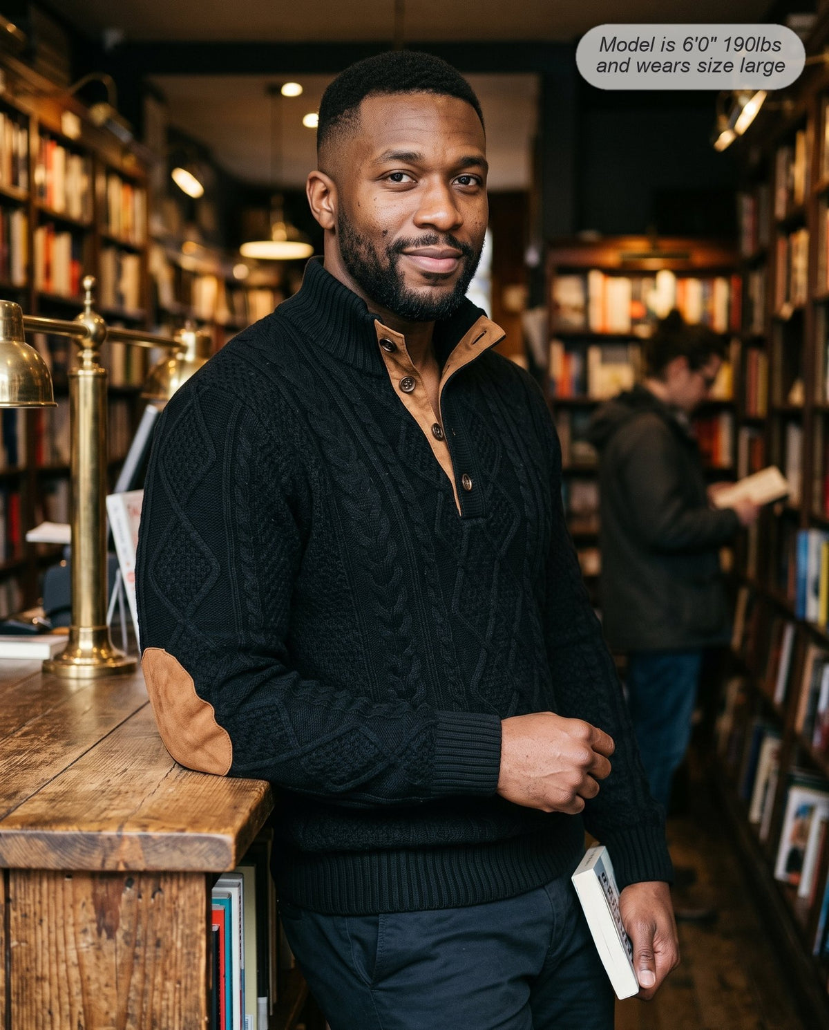 Man wearing the Bastion jacquard sweater in black in a bookshop