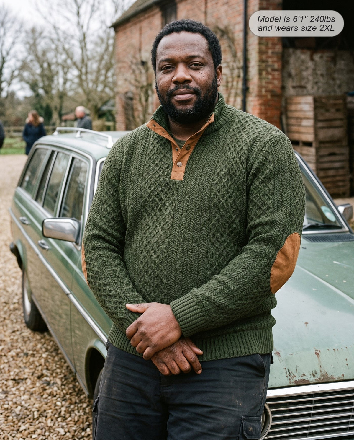 Man wearing the Bastion jacquard sweater in army green beside a classic car