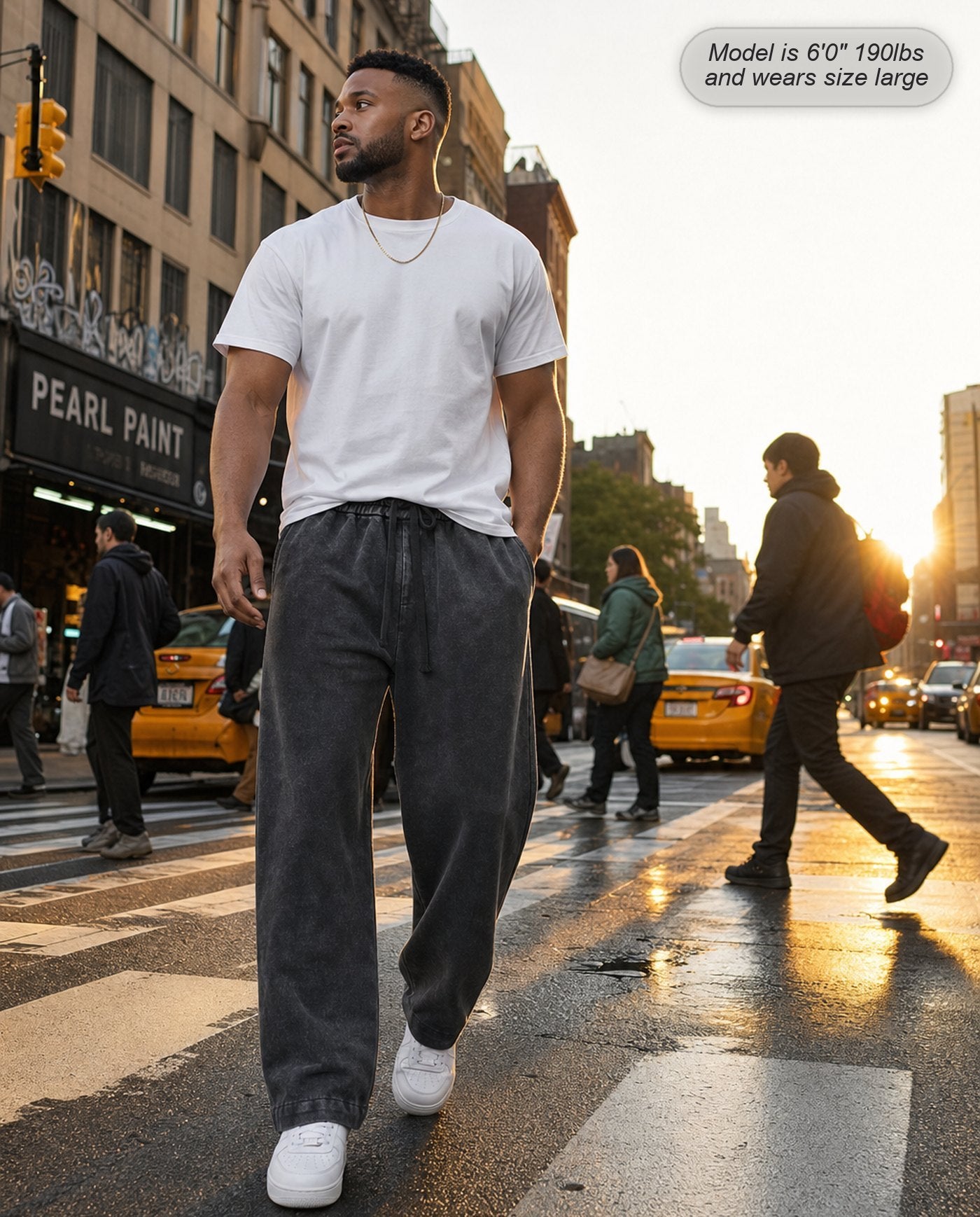 Man wearing Citadel relaxed acid wash sweatpants in washed black on a city crosswalk