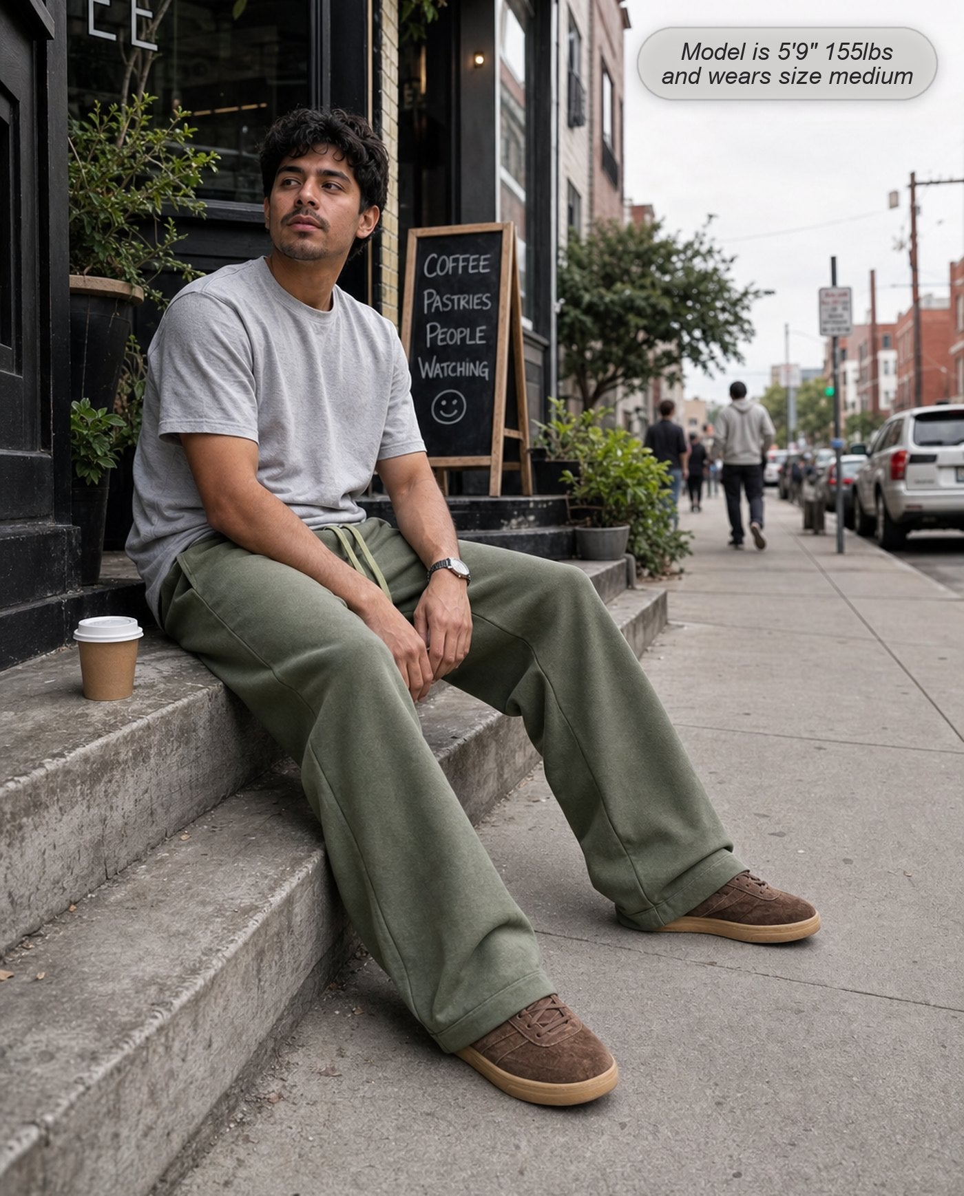 Man wearing Citadel sweatpants in washed army green outside a coffee shop