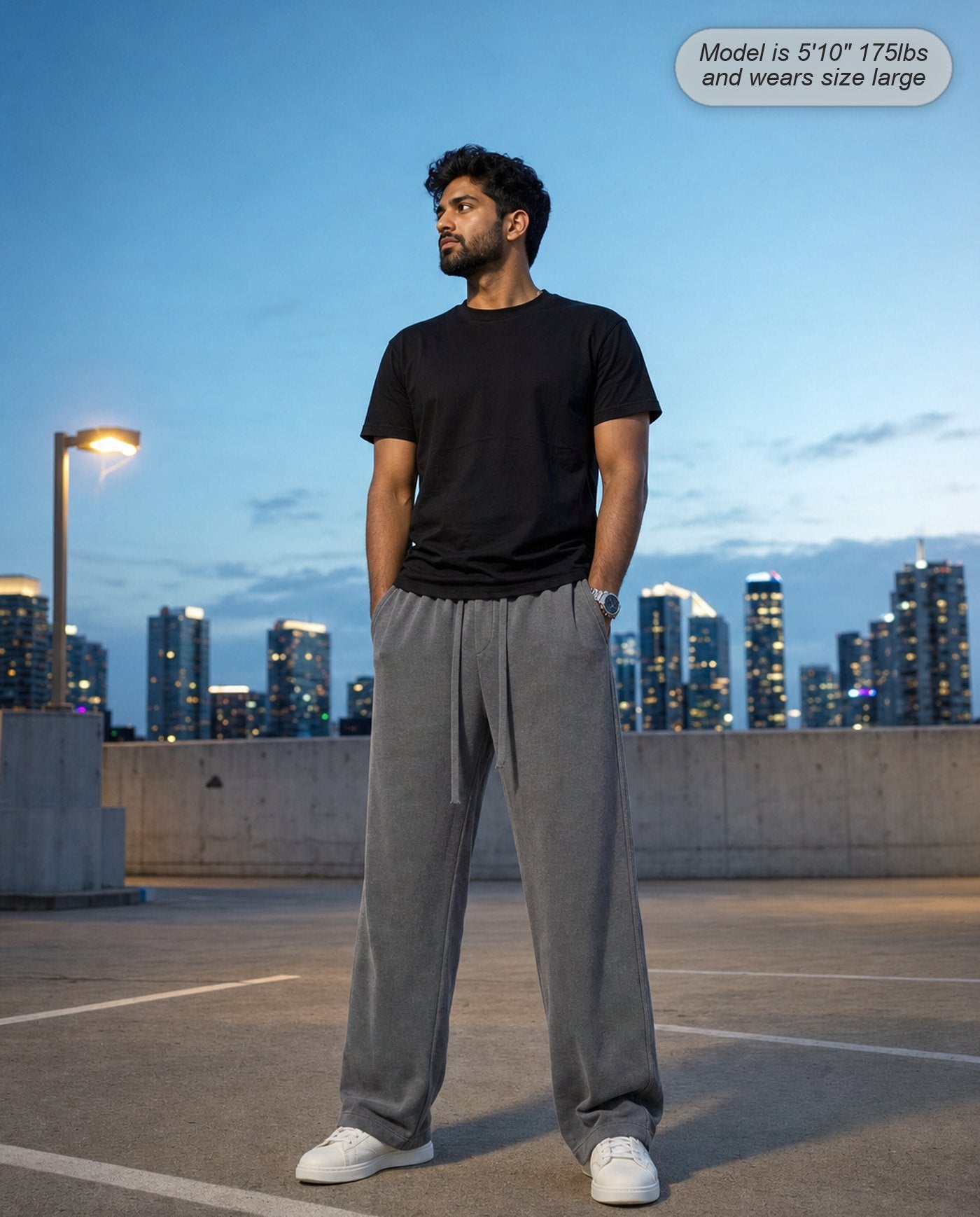 Man wearing Citadel sweatpants in washed grey on a rooftop at dusk