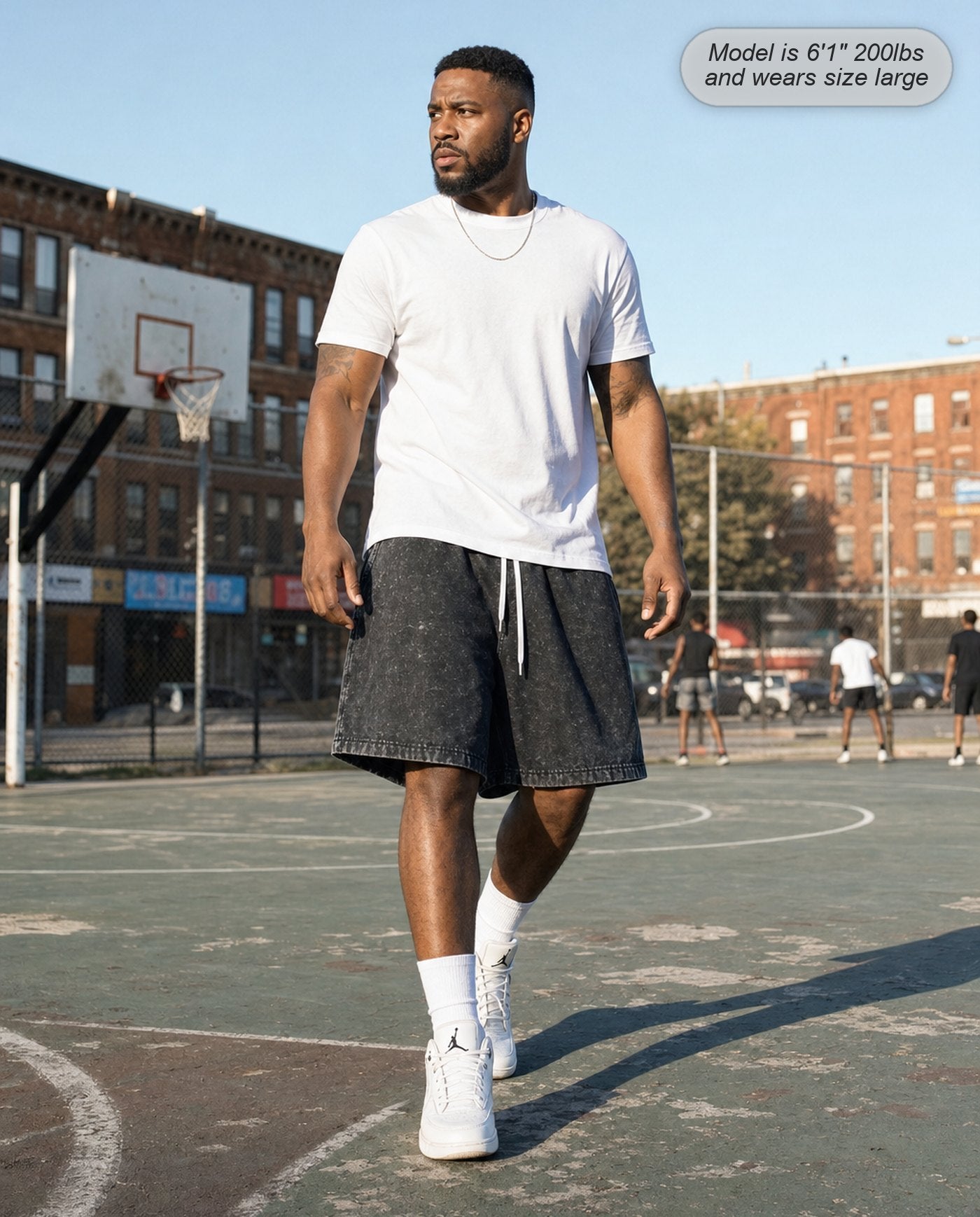 Man wearing Colossus baggy acid wash shorts in washed black on a basketball court