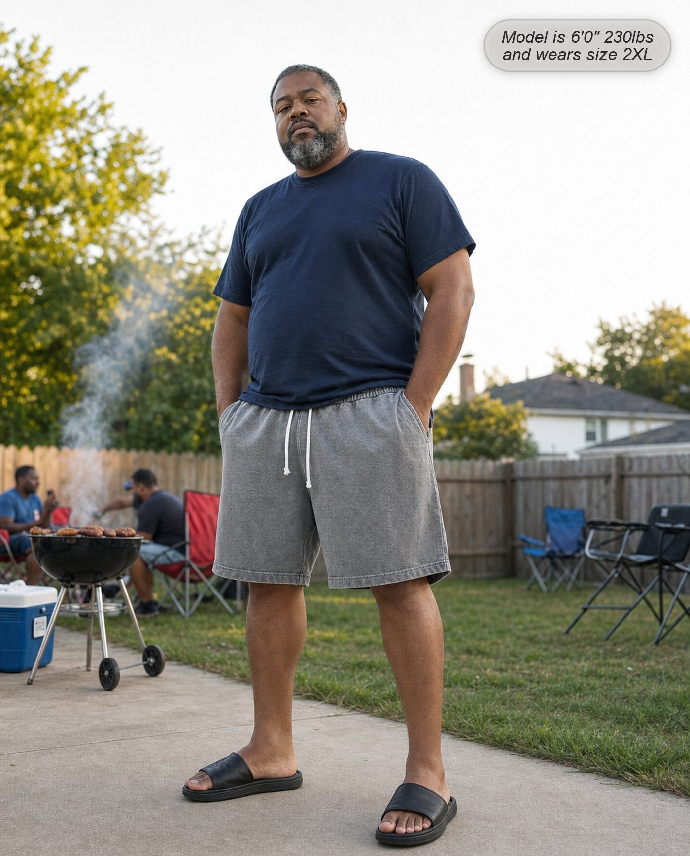 Man wearing Colossus shorts in stone grey at a backyard cookout