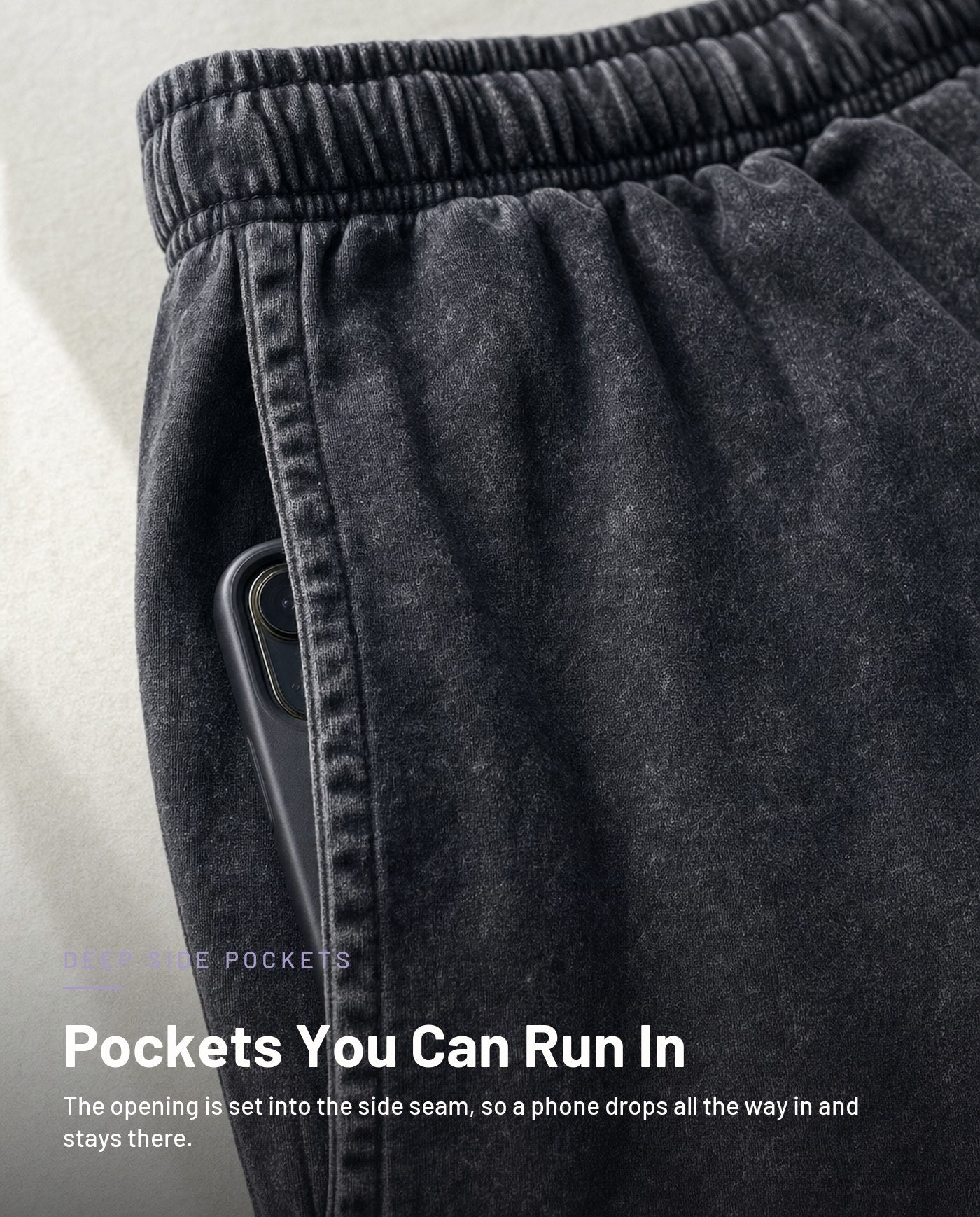 Deep side-seam pocket swallowing a phone, washed black