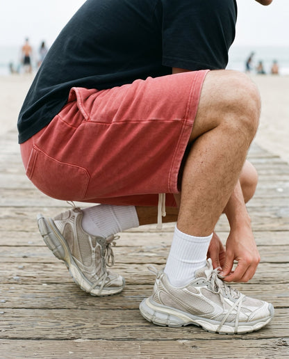 Crouched view of the Colossus baggy shorts in washed red