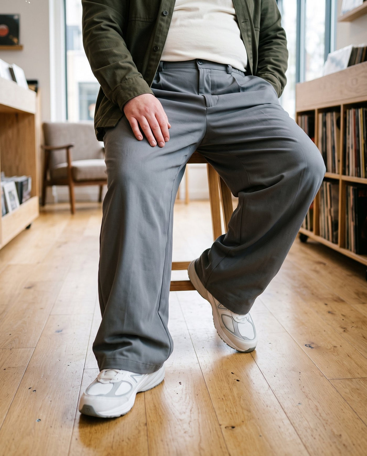 Seated view showing the Envoy trousers in charcoal draping over the thigh