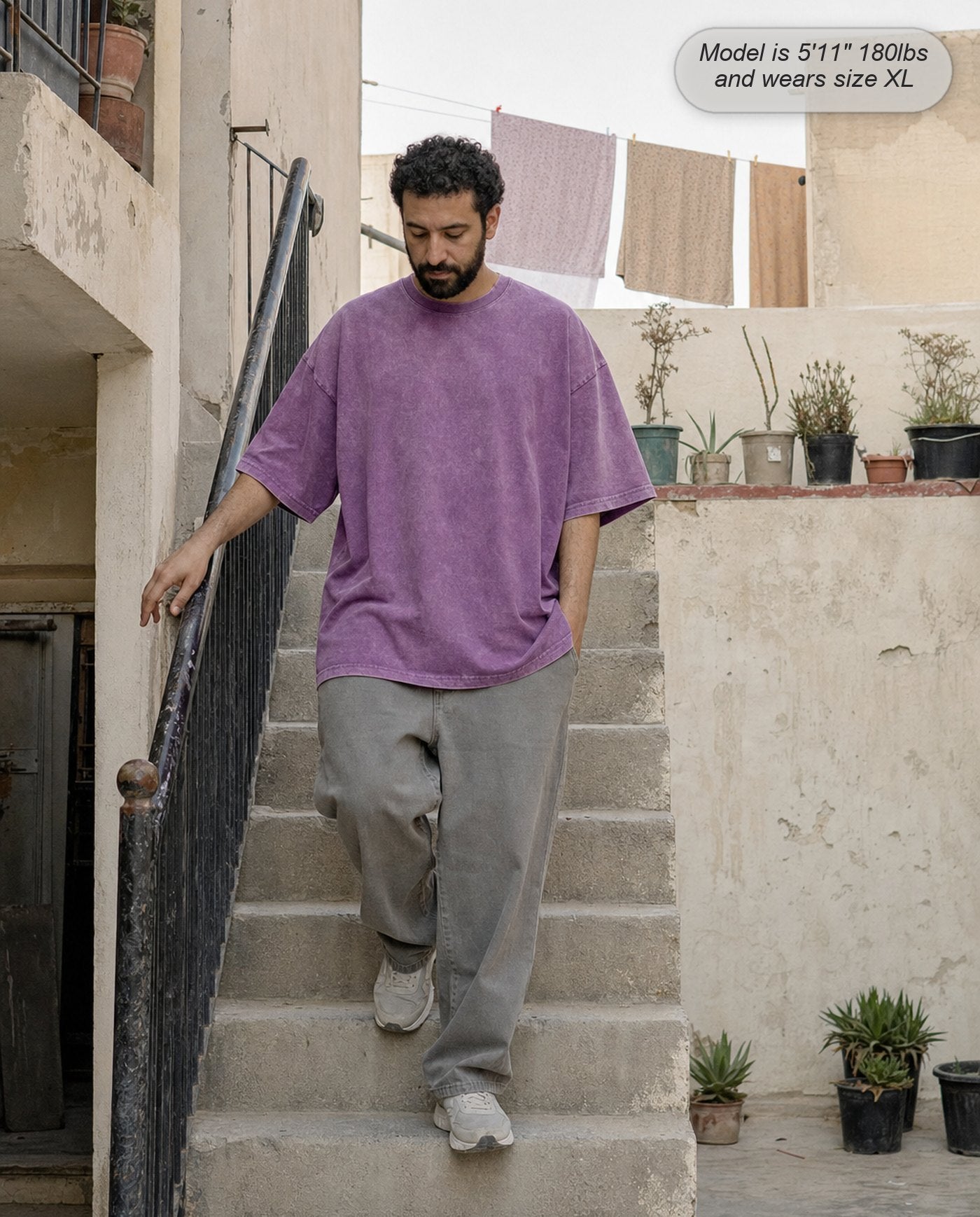Man in a Washed Purple Legion oversized acid wash tee on outdoor steps