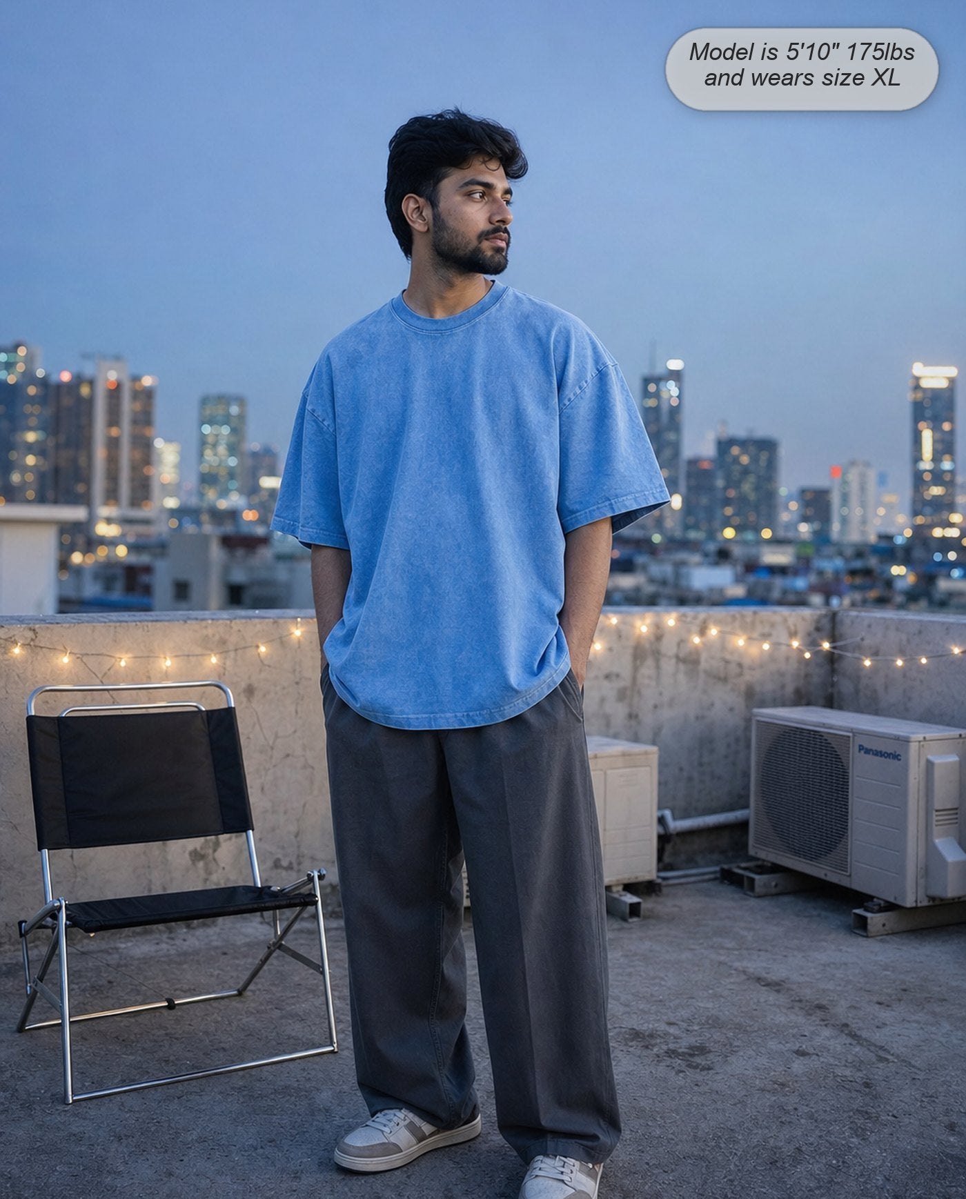 Man in a Sapphire Blue Legion oversized acid wash tee on a rooftop at dusk