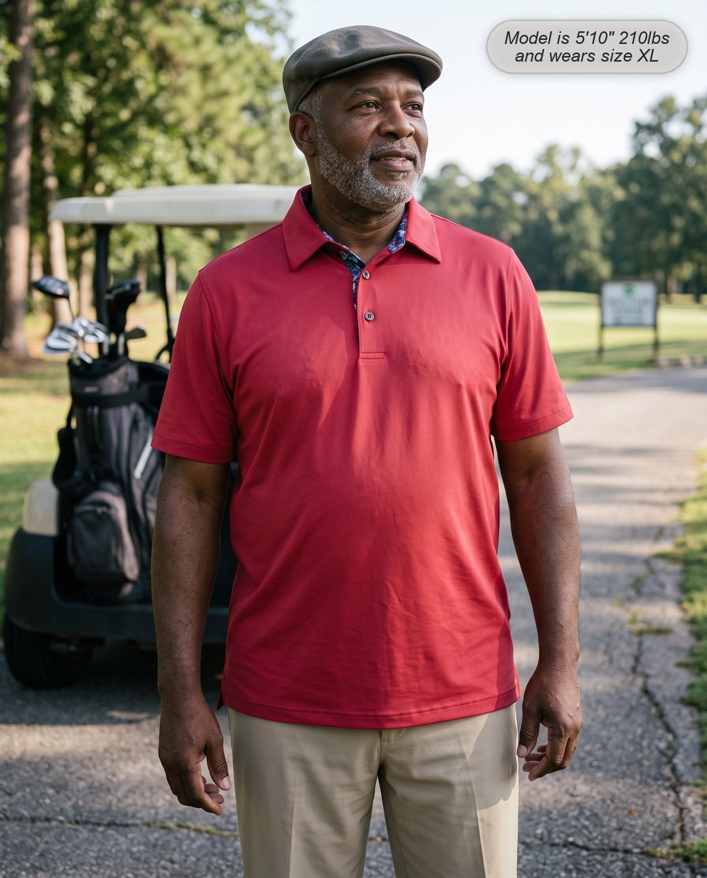 Man wearing the Meridian golf polo in crimson beside a golf cart