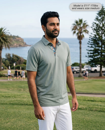 Man wearing the Meridian golf polo in sage on a coastal course
