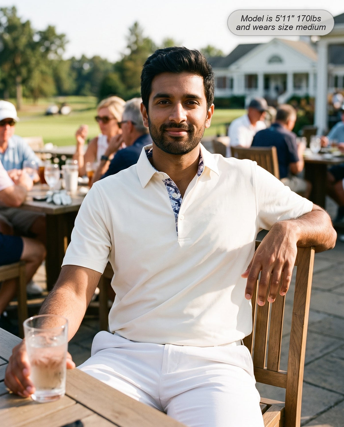 Man wearing the Meridian golf polo in ivory on the clubhouse terrace