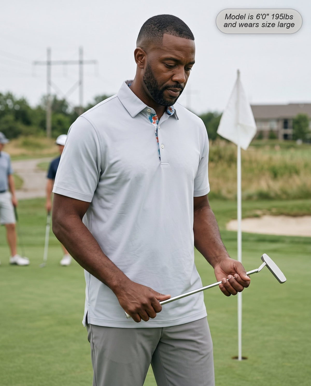 Man wearing the Meridian golf polo in silver on the putting green