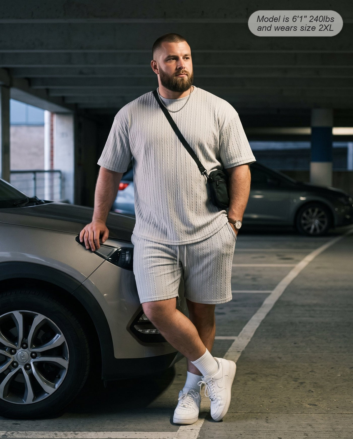 Man wearing the Monarch lounge short set in silver beside a car