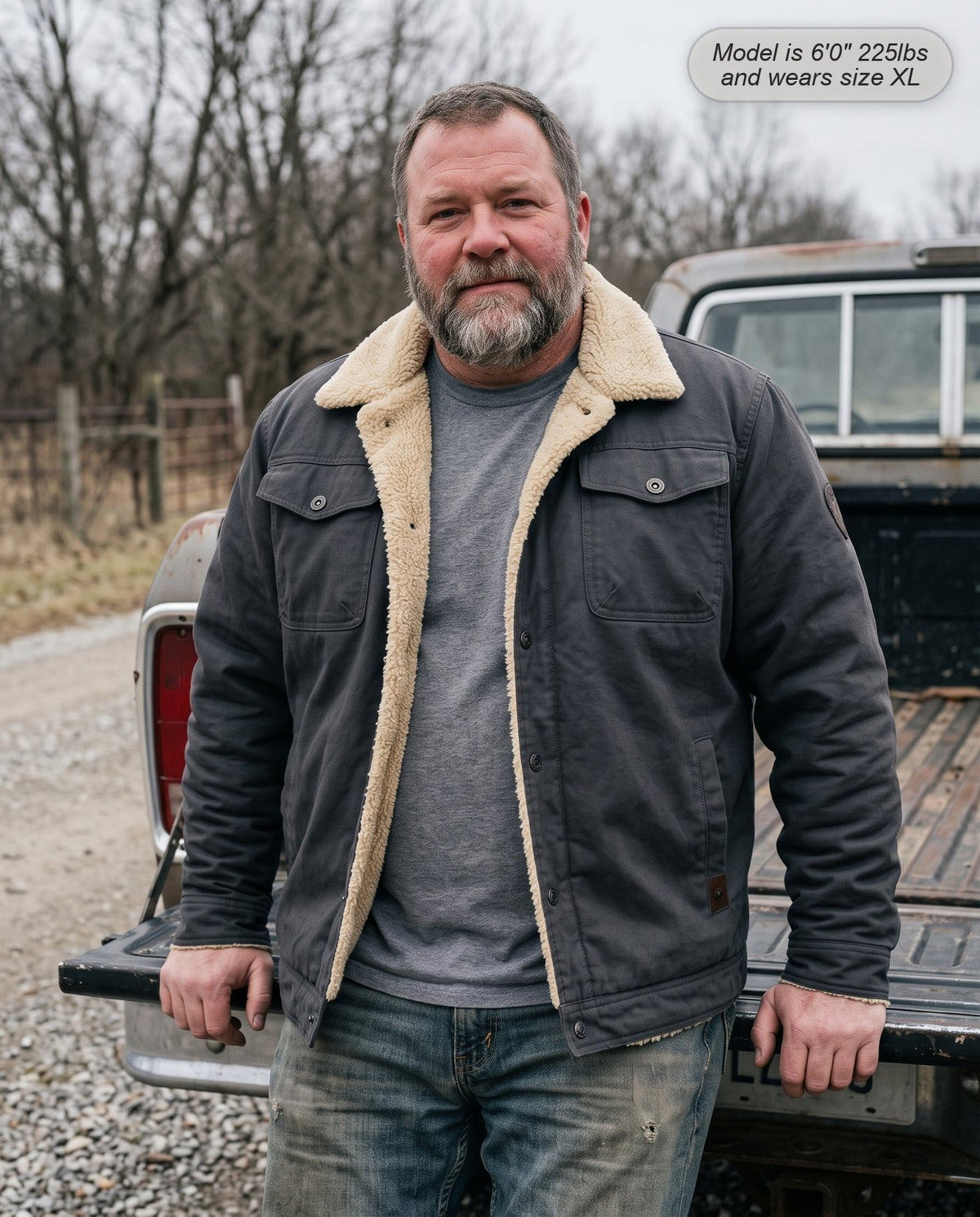 Man wearing the Sentinel sherpa jacket in charcoal grey by a pickup truck