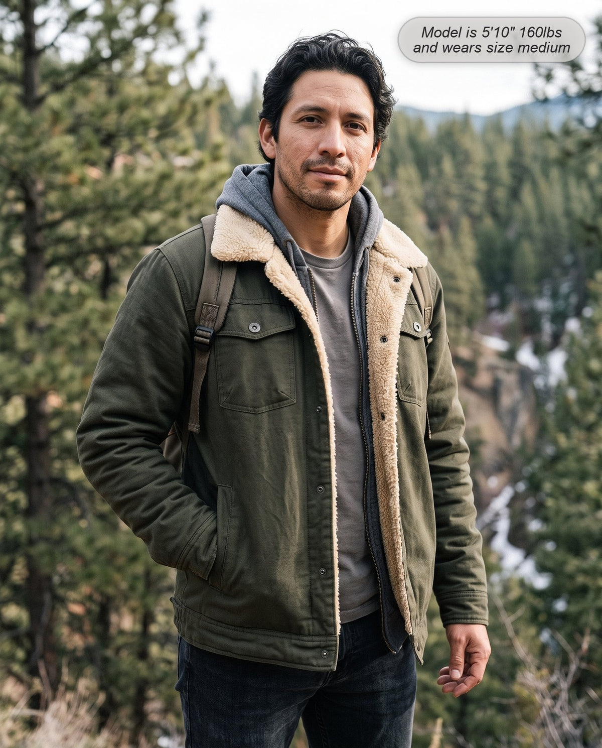 Man wearing the Sentinel sherpa jacket in olive green at a mountain trailhead