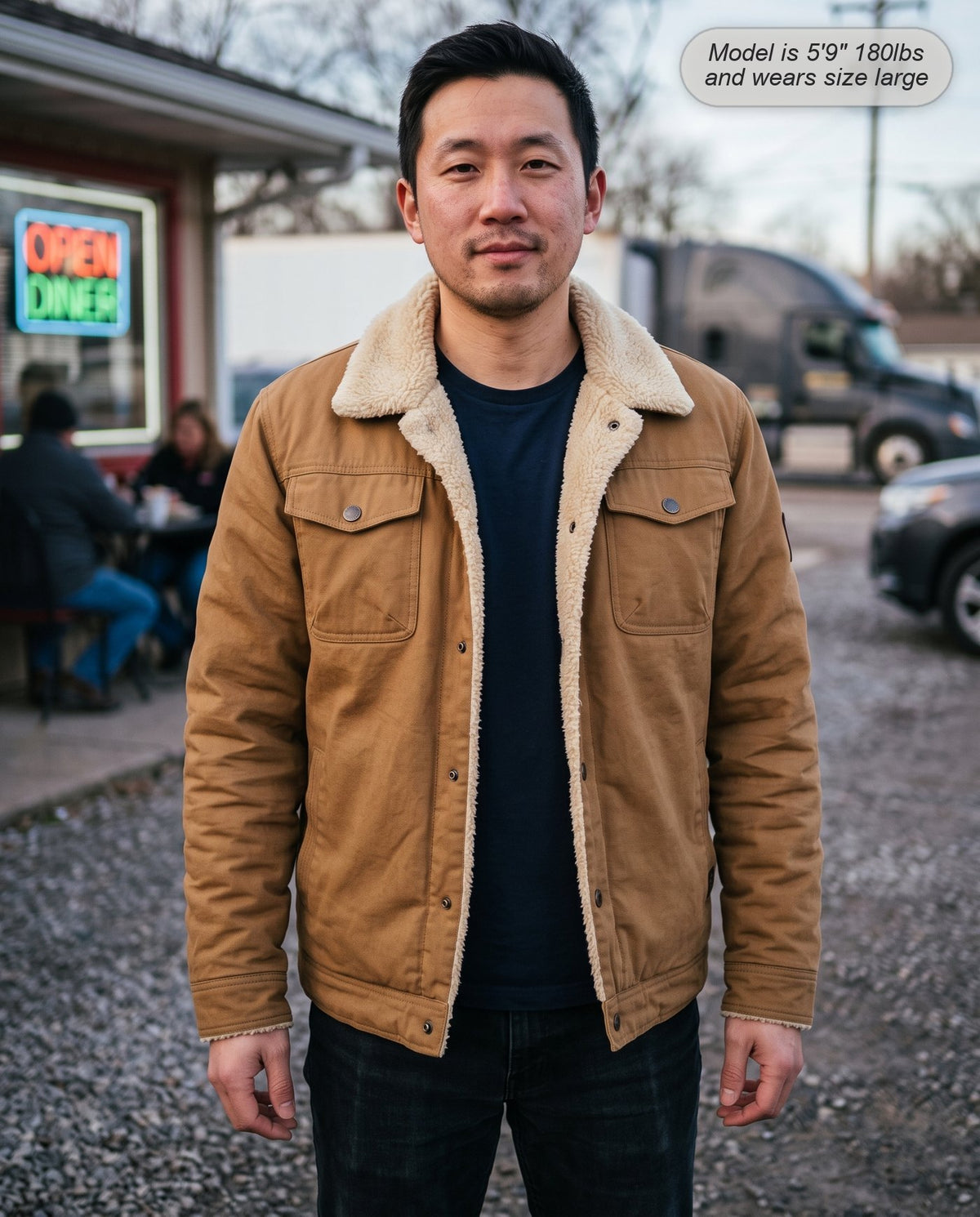 Man wearing the Sentinel sherpa jacket in camel outside a roadside diner